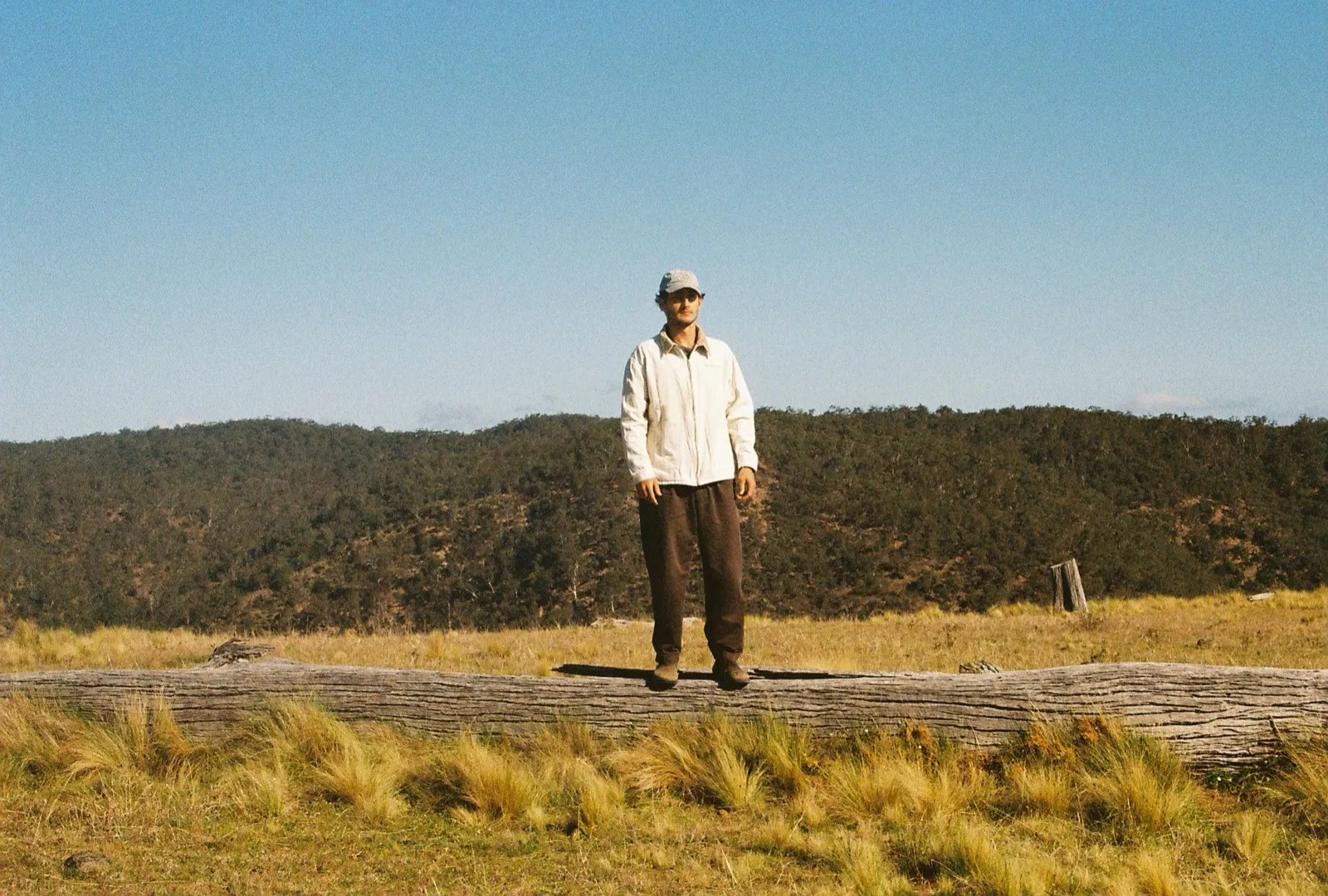 A team member standing on a fallen log in the Australian bush