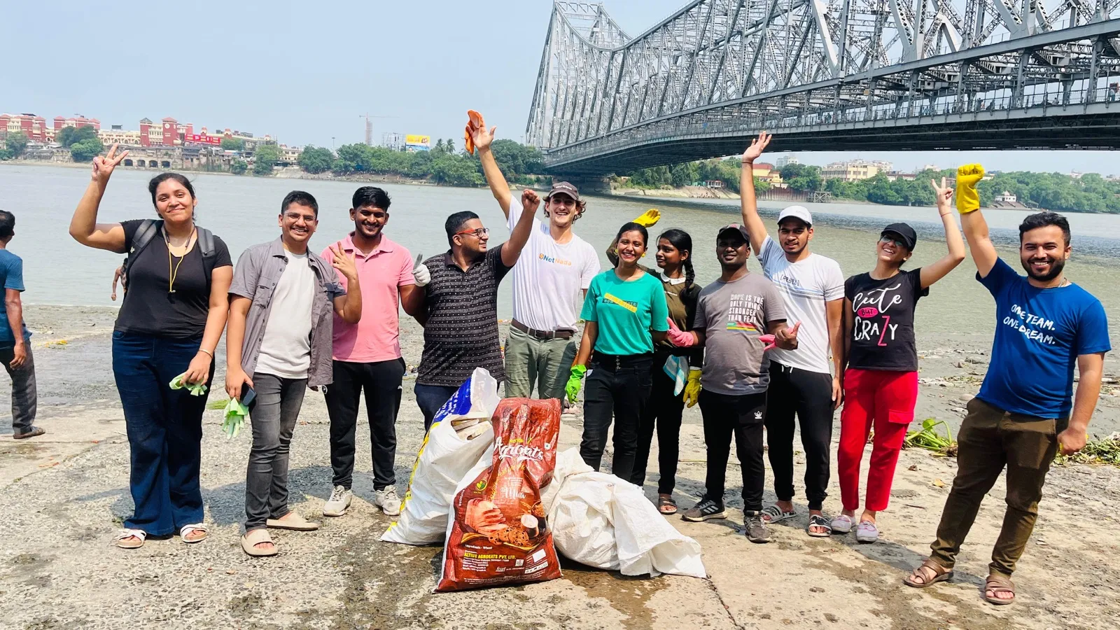 The team celebrating a river clean-up under Howrah Bridge in Kolkata
